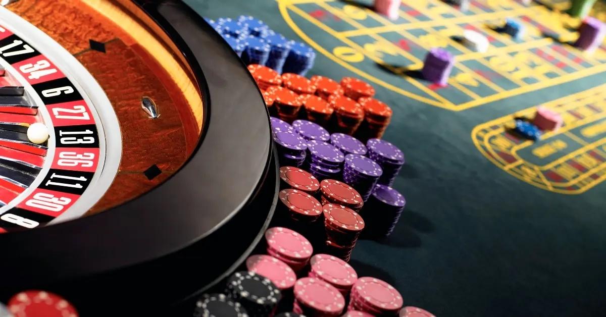 A Russian roulette table with poker chips stacked beside it.