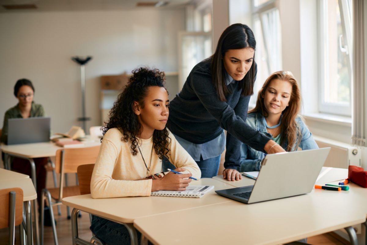 High school teacher assisting students in her classroom