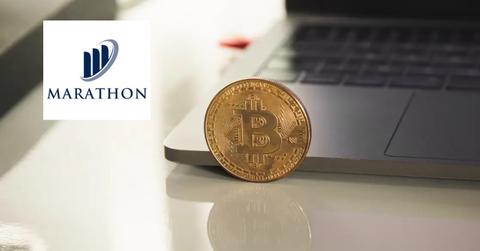 Bitcoin next to a laptop