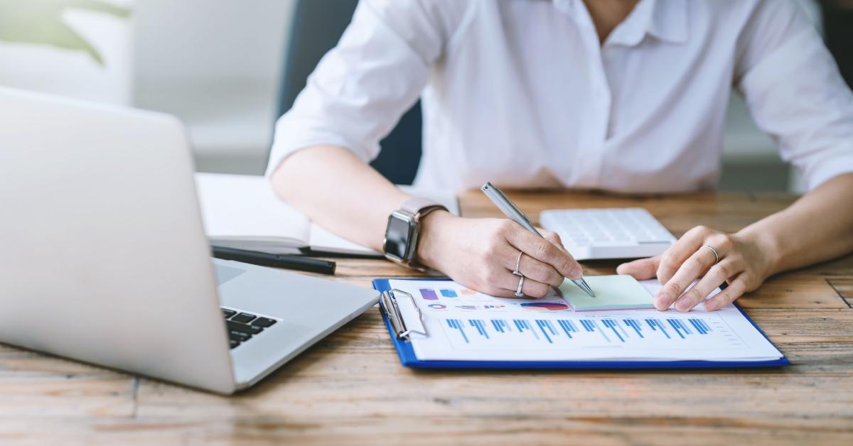 A person sits at a desk assessing their budget using their $65K salary.