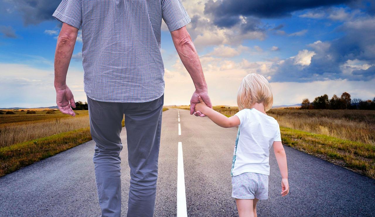 An adult and child walking and holding hands