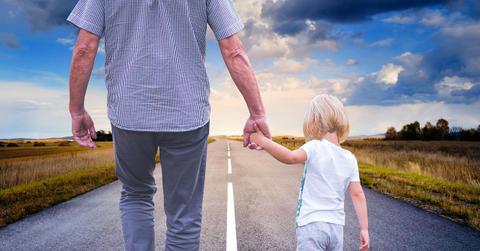 An adult and child walking and holding hands