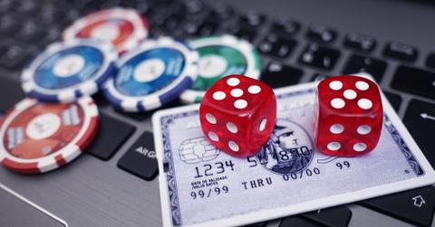 Poker chips, dice, and a credit card on a laptop keyboard