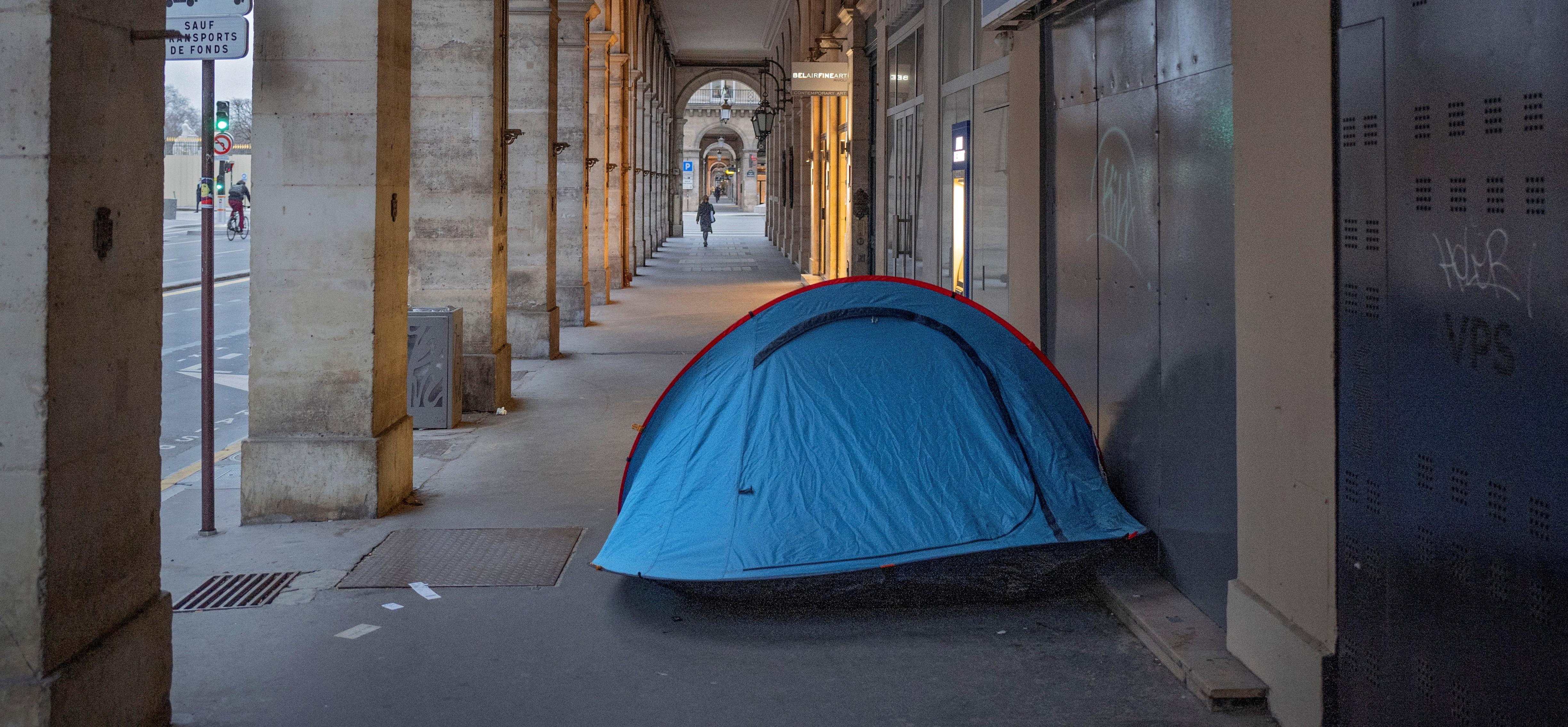 Homeless person in tent on sidewalk