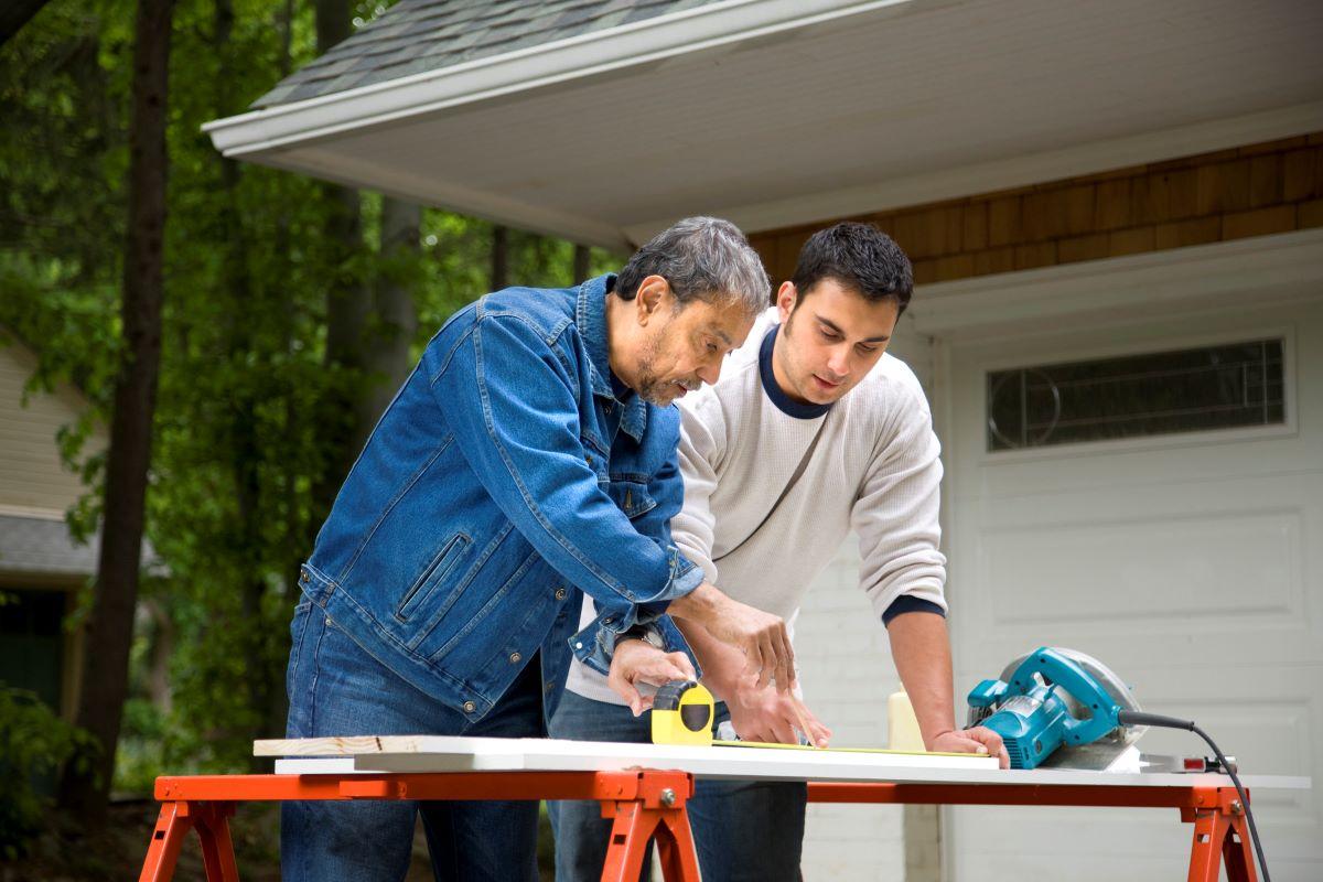 Man working with son to fix up a house