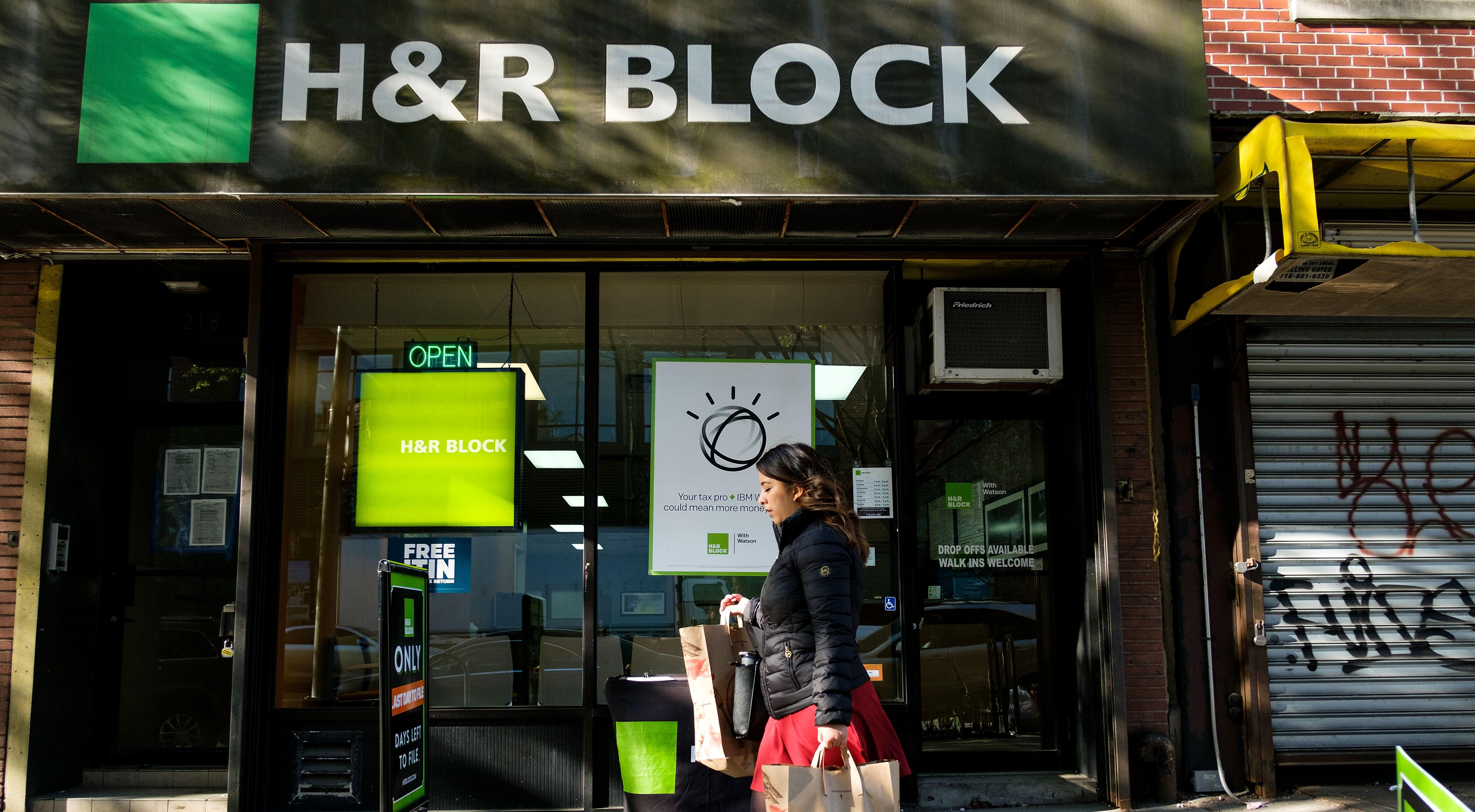 woman walking on sidewalk outside of h&r block tax center