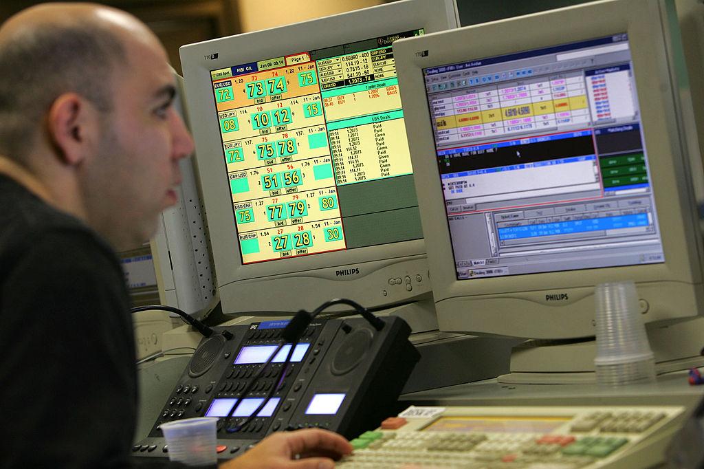 A forex trader looking at computer screens