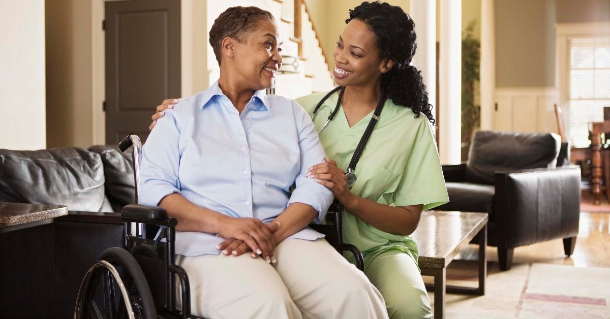 A woman in a wheelchair with her patient care coordinator. 