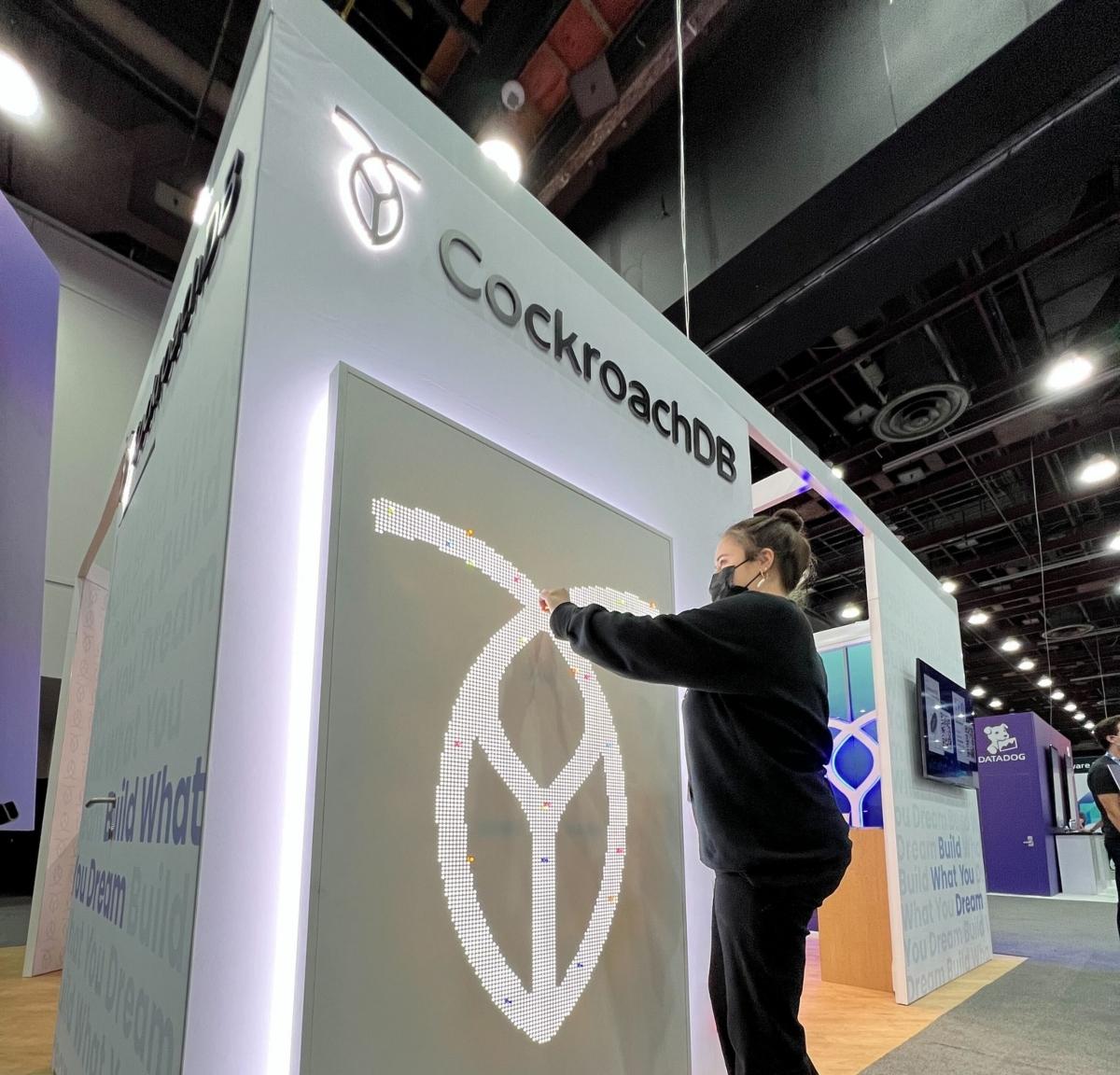 A woman working on a Cockroach Labs display