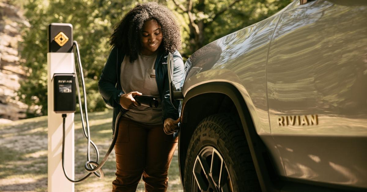 A person charging a Rivian Automotive EV