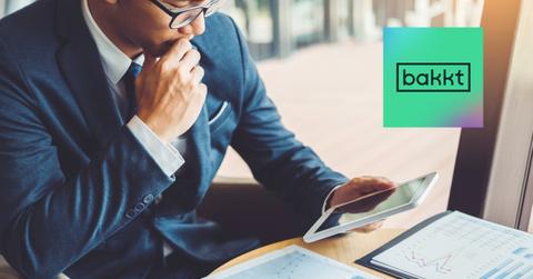 Man looking at a tablet and Bakkt logo