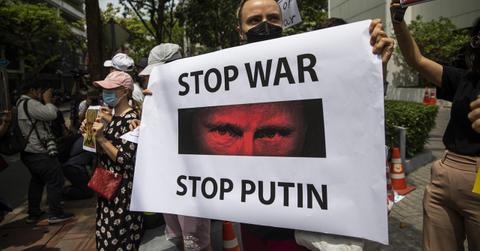 A woman holding a sign protesting the Russia-Ukraine war and Putin