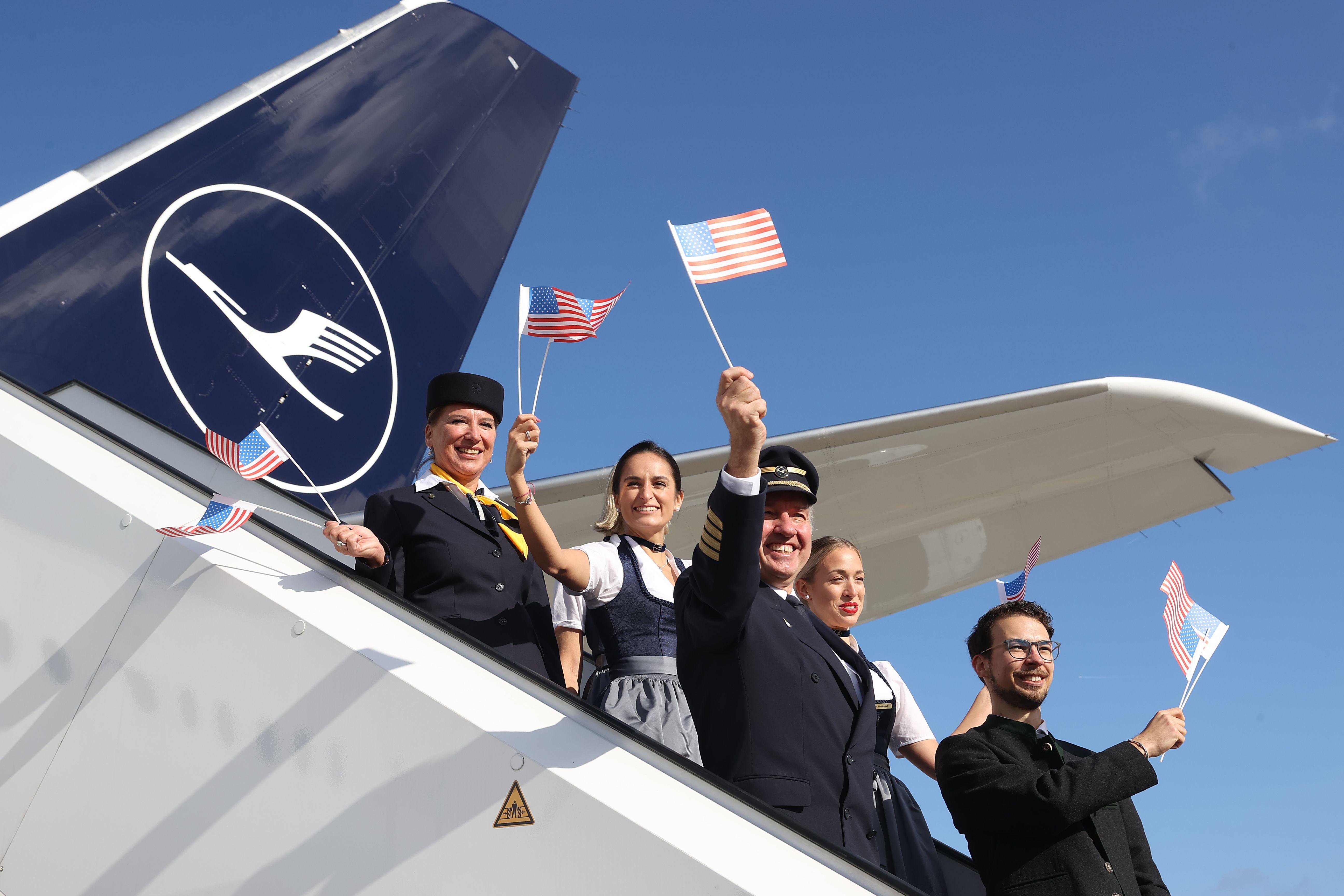 People waving flags while boarding a plane