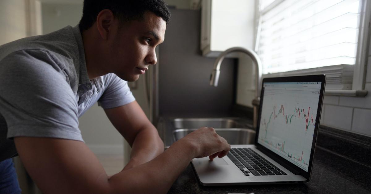 A person looking a a stock chart on a laptop