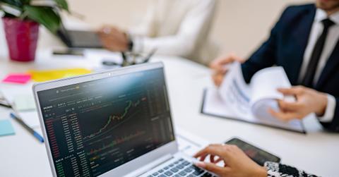 A person using a laptop to look at graphs