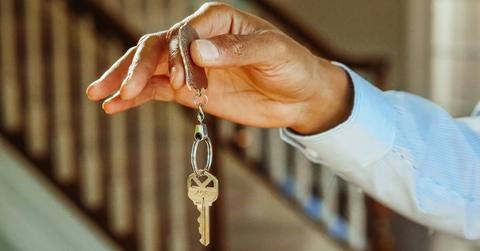 Person Holding a Silver Keychain with a Key