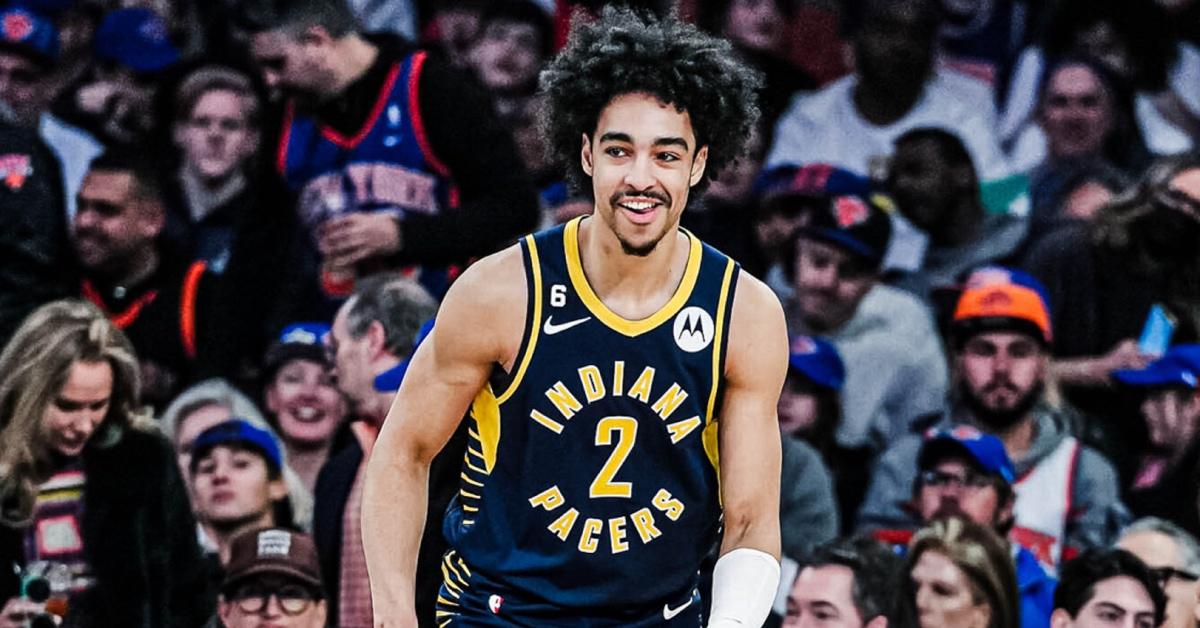 Indiana Pacers player Andrew Nembhard smiles on the court mid-game.