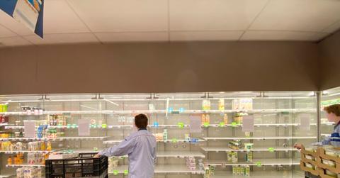 A person looking at empty supermarket shelves