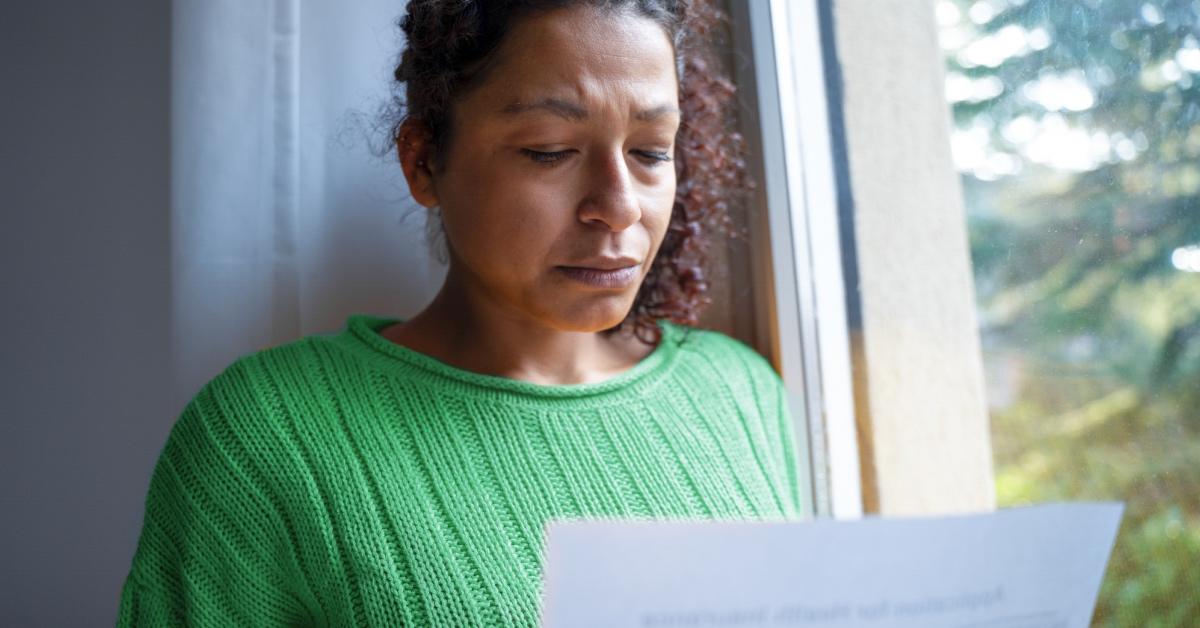  A concerned woman reading a letter.