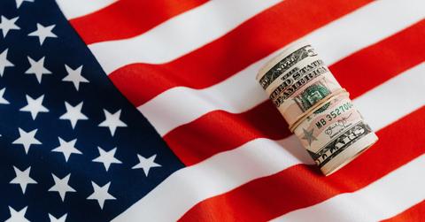 American flag with rolled dollar bills