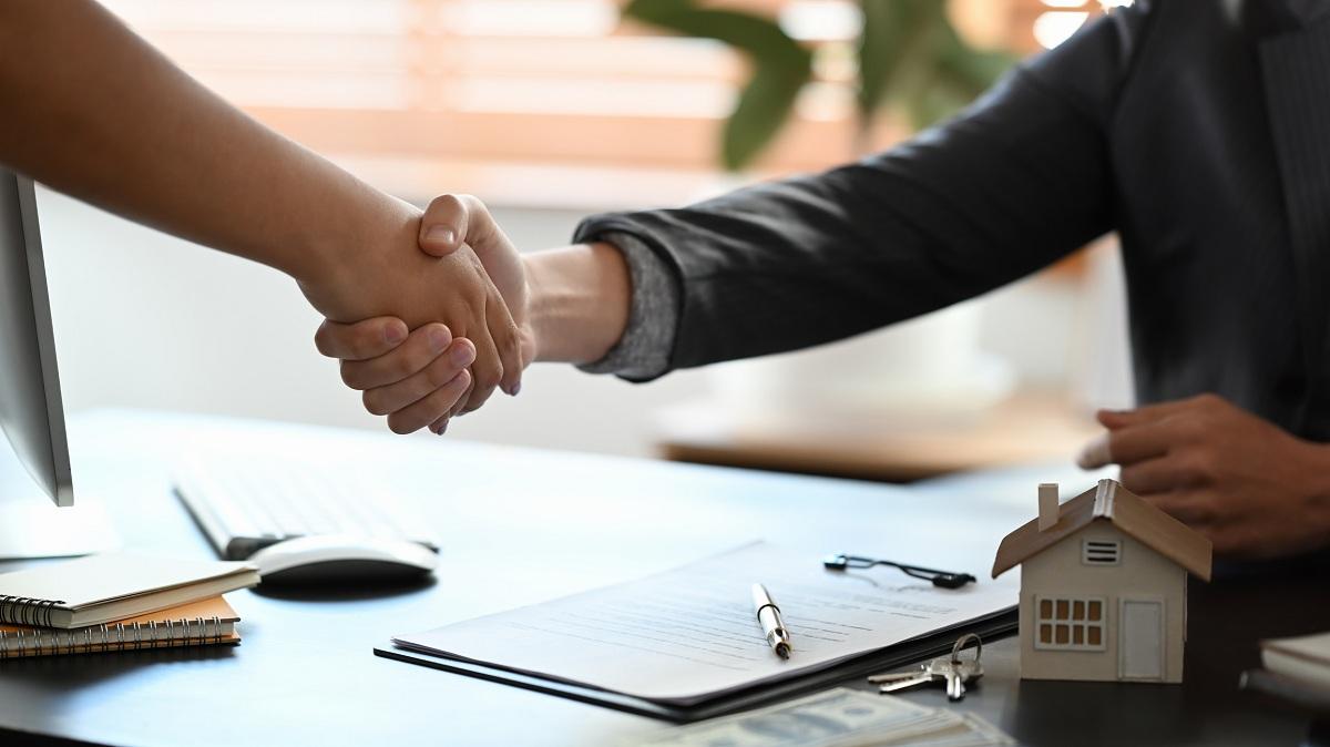 People shaking hands after signing a mortgage contract