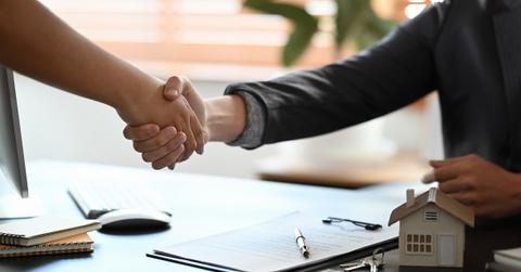People shaking hands after signing a mortgage contract