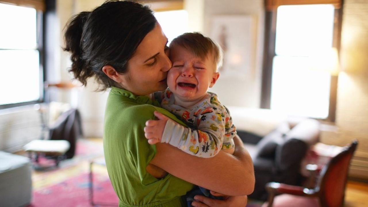 A woman holding a crying baby