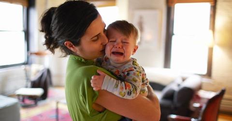 A woman holding a crying baby