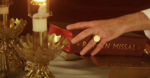 Priest hand on Roman Missal book