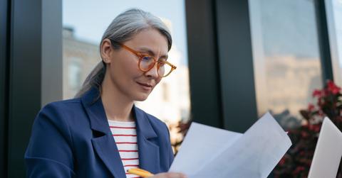 A woman looking at Simple IRA vs. 401(k) documents