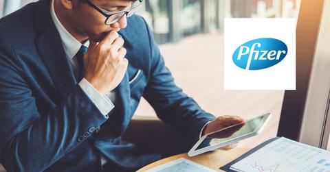 Man looking at data and Pfizer logo