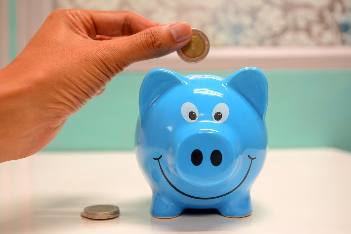 Person putting coin in a pggy bank