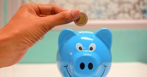 Person putting coin in a pggy bank