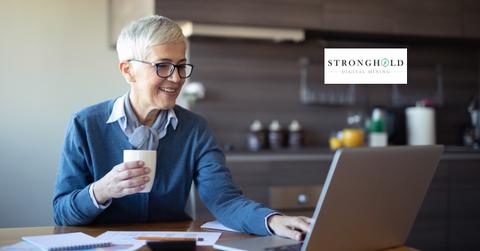 Woman looking on a laptop and Stronghold Digital Mining logo