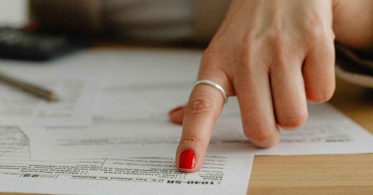 A finger pointing at a U.S. form 1040. 