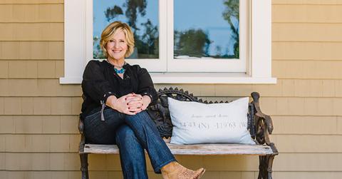 Brené Brown sitting on bench outside of window