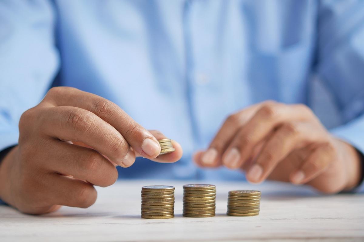 A person counts coins on a table