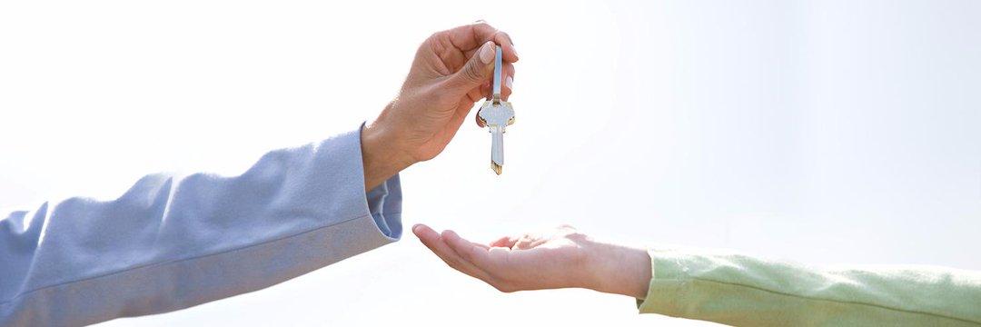 A person handing over house keys