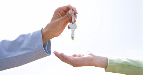 A person handing over house keys