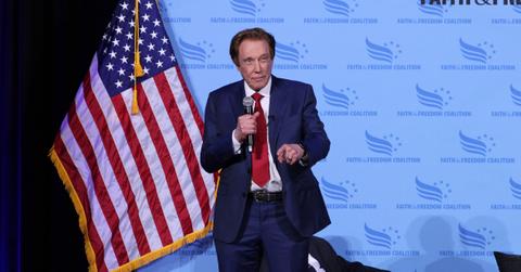 Perry Johnson talking on stage with an American flag behind him