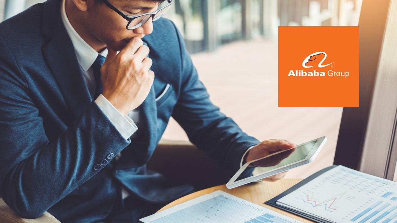 Man looking at data on a tablet and Alibaba logo