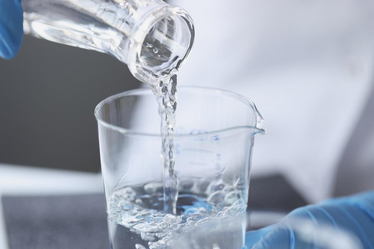 Scientist examines drinking water in laboratory closeup