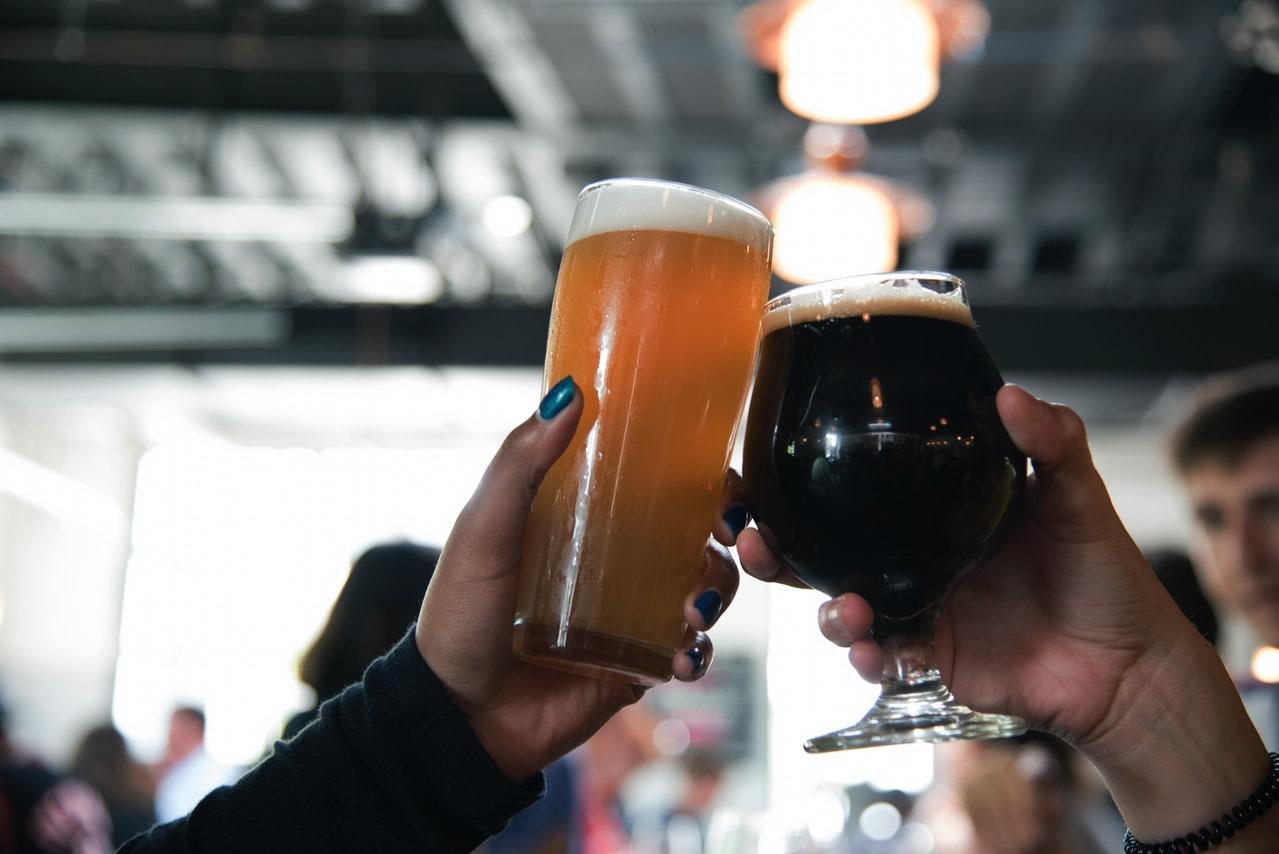 People doing a toast with beer mugs