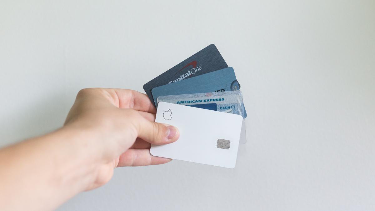 A person holding four credit cards