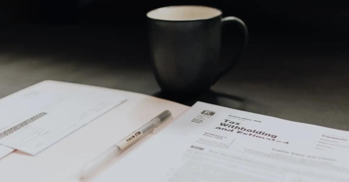 Tax forms sit in a folder on top of a desk.