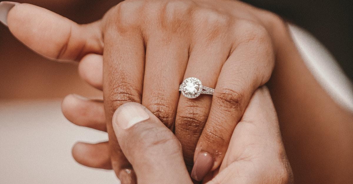 A newly engaged couple holding hands