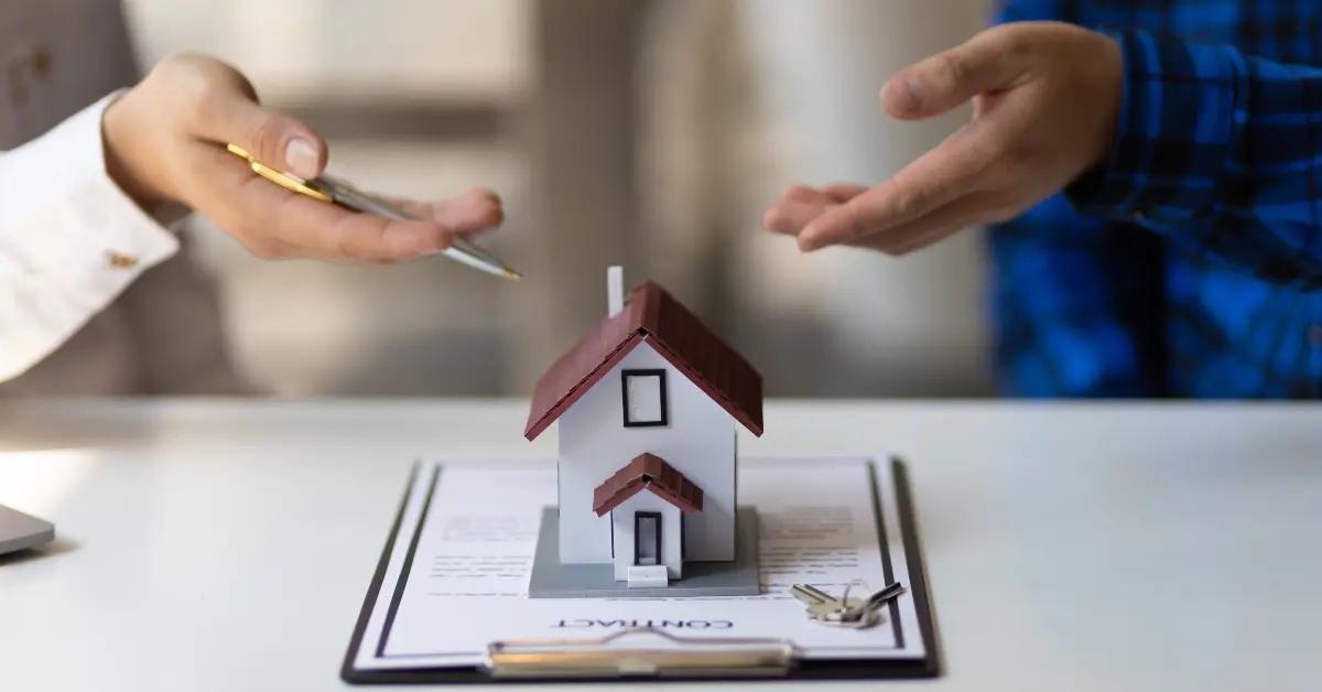 A figure of a house sitting on top of a tax deed.