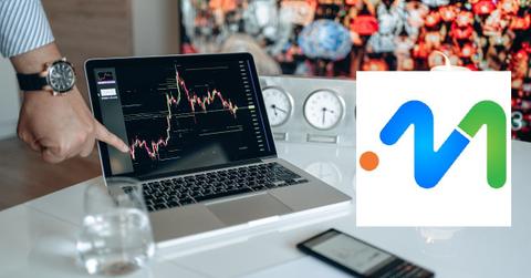 A person pointing to a crypto price chart on a laptop