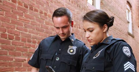 Two police officers looking at a cell phone