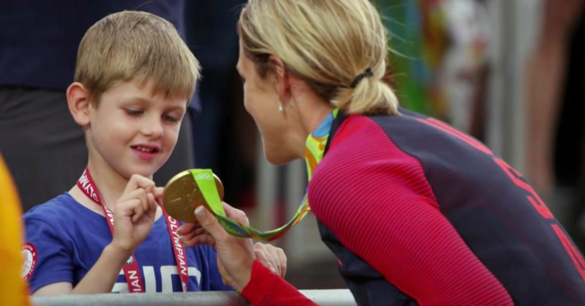 An athlete showing a child her gold medal